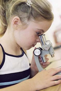 fillette en train de regarder dans un microscope