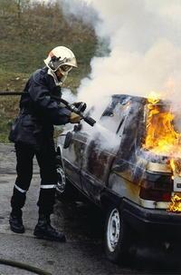 Pompier en train d'eteindre un feu voiture