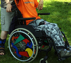 Jambes d'un jeune polyhandicapé en fauteuil