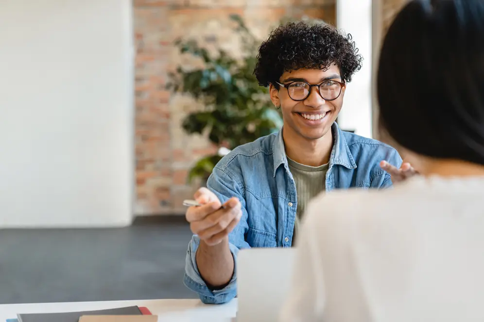 Jeune en recherche d'emploi échangeant sur son projet professionnel avec une conseillère.