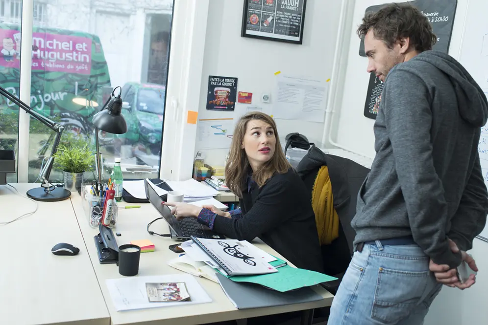 Réunion de travail entre la directrice de la communication et Augustin au sein de l'entreprise Michel et Augustin