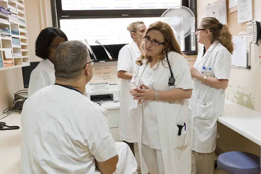 Soignants échangeant dans une salle au sein d'un groupe hospitalier.