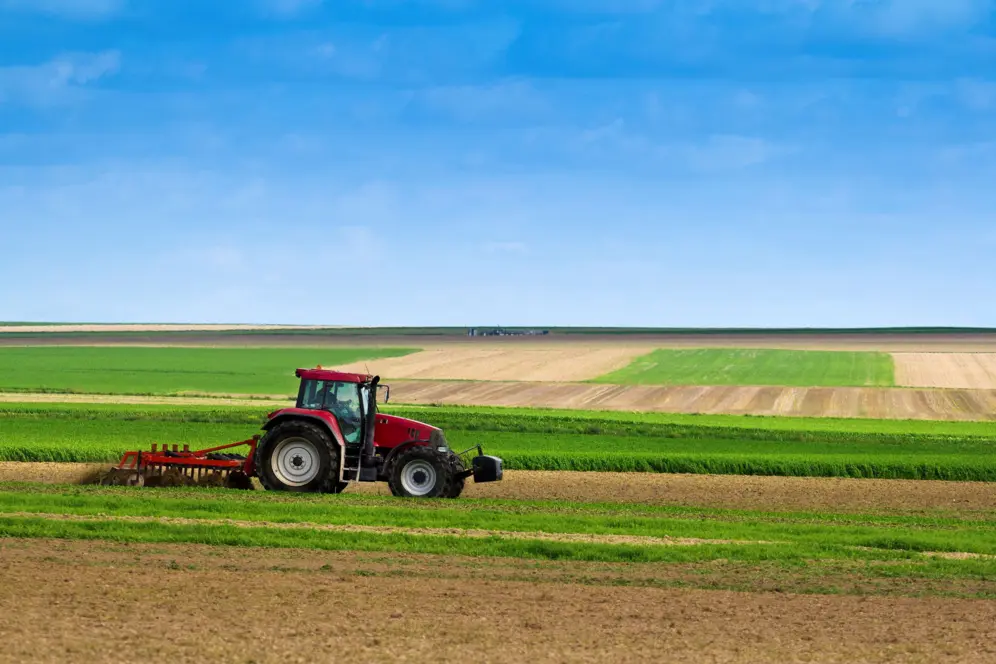 Tracteur sur fond de champs cultivés