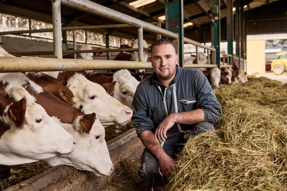 Eleveur dans une étable devant ses vaches