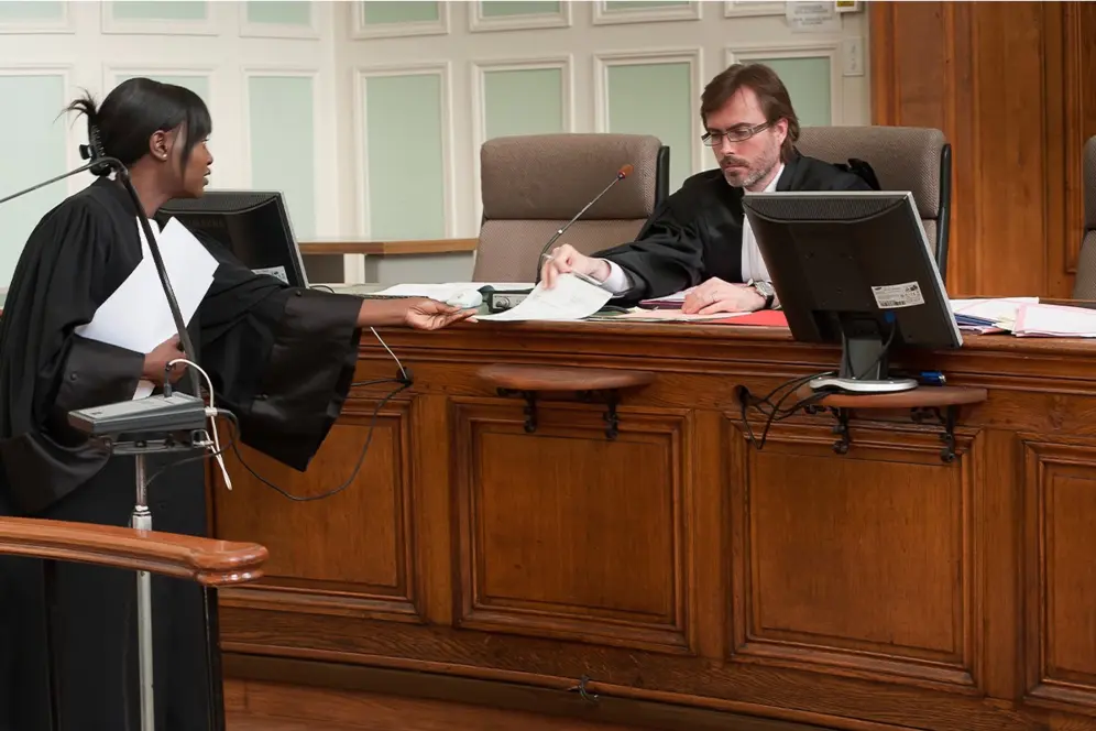 Femme tendant une feuille à un homme dans un tribunal