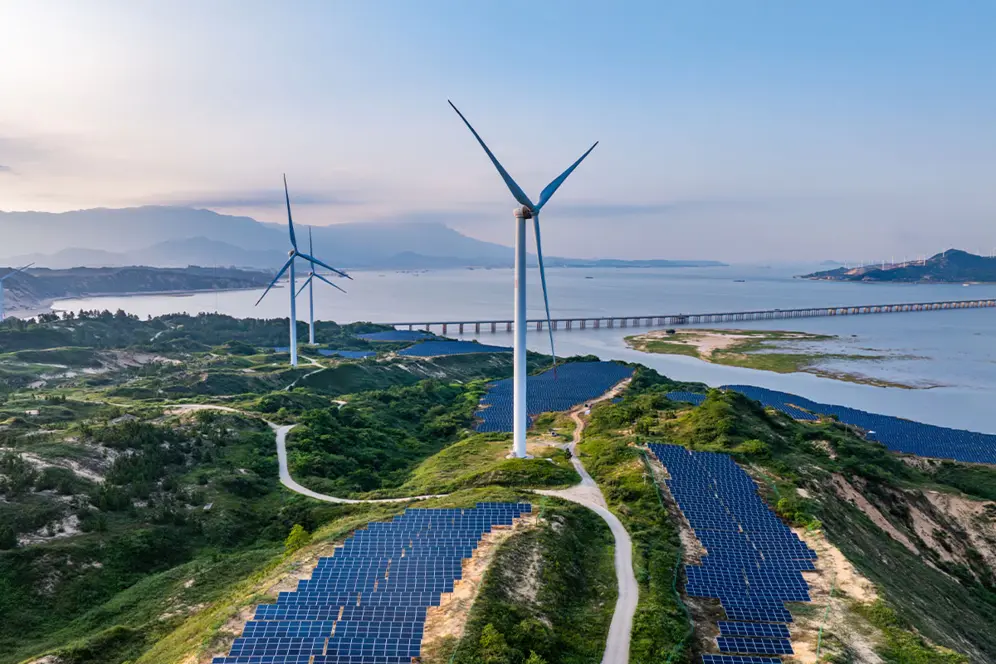 Paysage avec des panneaux solaires et des éoliennes au bord d'un fleuve