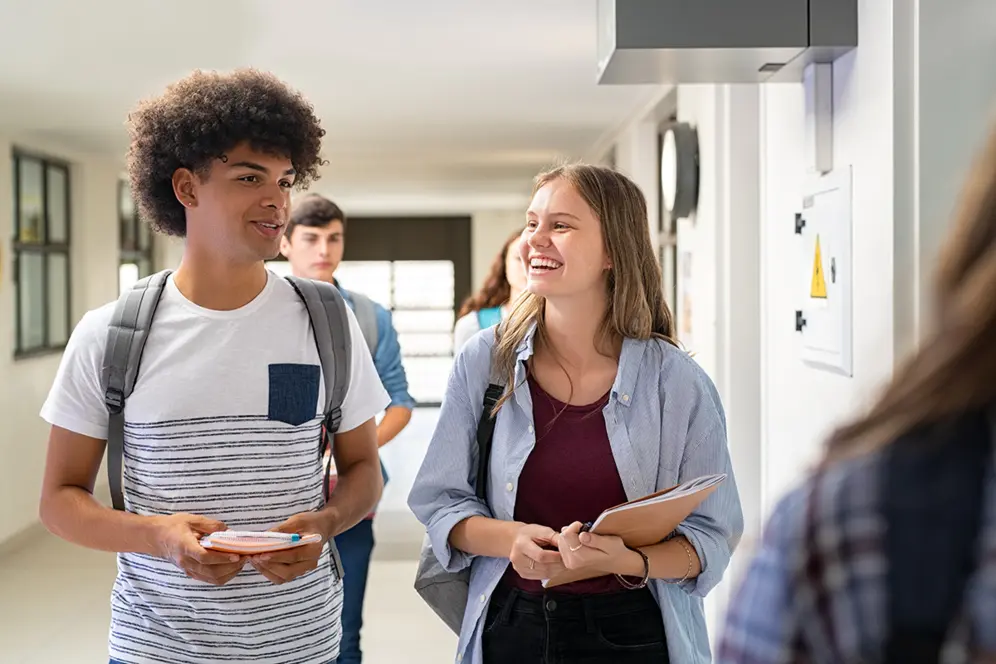 Élèves échangeant en marchant dans le couloir d'un lycée professionnel, d'un lycée général ou d'un lycée technologique.
