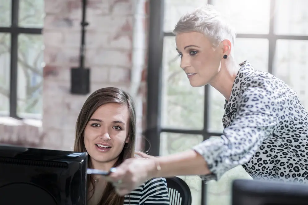 Étudiante en apprentissage suivant un cursus universitaire et accompagnée par une maîtresse d'apprentissage en entreprise.