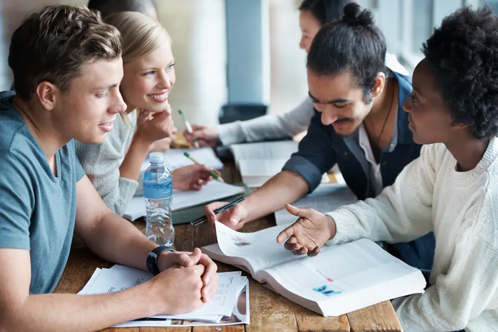 Jeunes engagés dans une prépa Talents révisant les concours d’accès aux écoles de la fonction publique dans un espace de travail.
