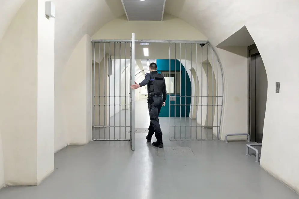 Surveillant pénitentiaire circulant dans un couloir sécurisé d'un établissement pénitentiaire