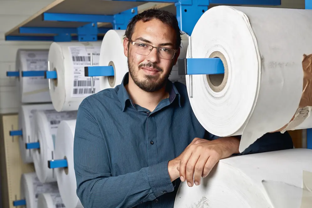 Portrait de Victor accoudé sur une bobine de papier.