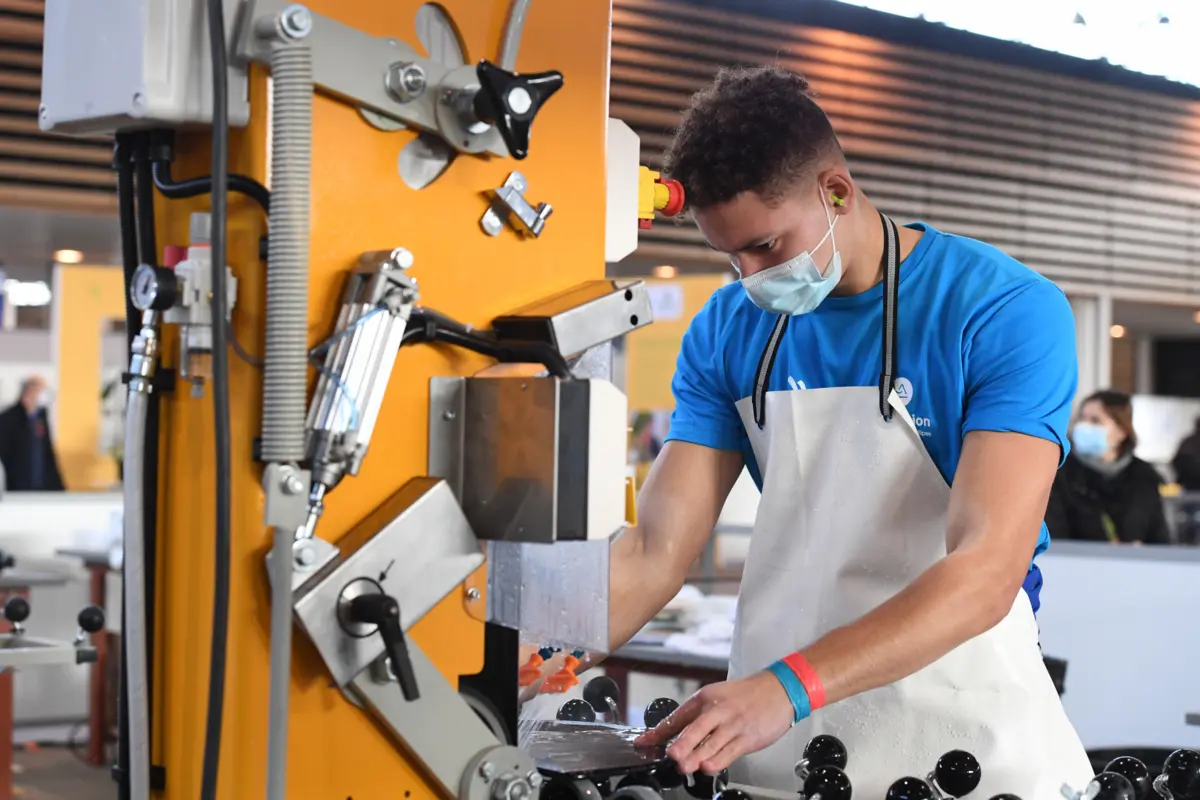 Jeune miroitier en travaux de coupe de verre en atelier