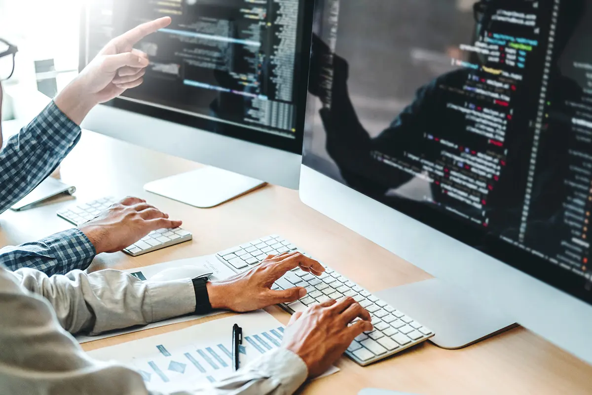 Des développeurs tapent des lignes de code sur leur écran