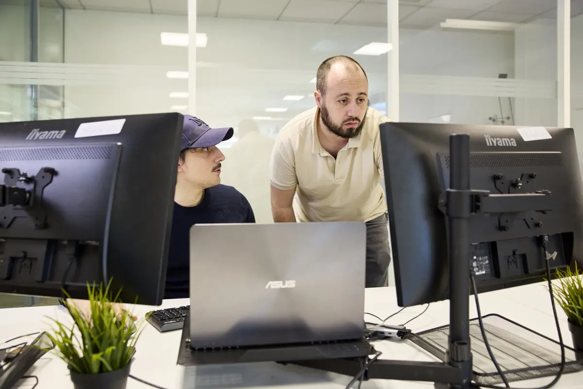 Thibault, d&eacute;veloppeur, et Axel, chef de projet, examinent ensemble l'avanc&eacute;e d'un projet