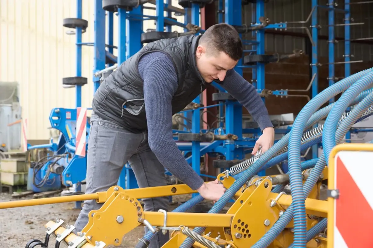 Agriculteur r&eacute;parant un tracteur