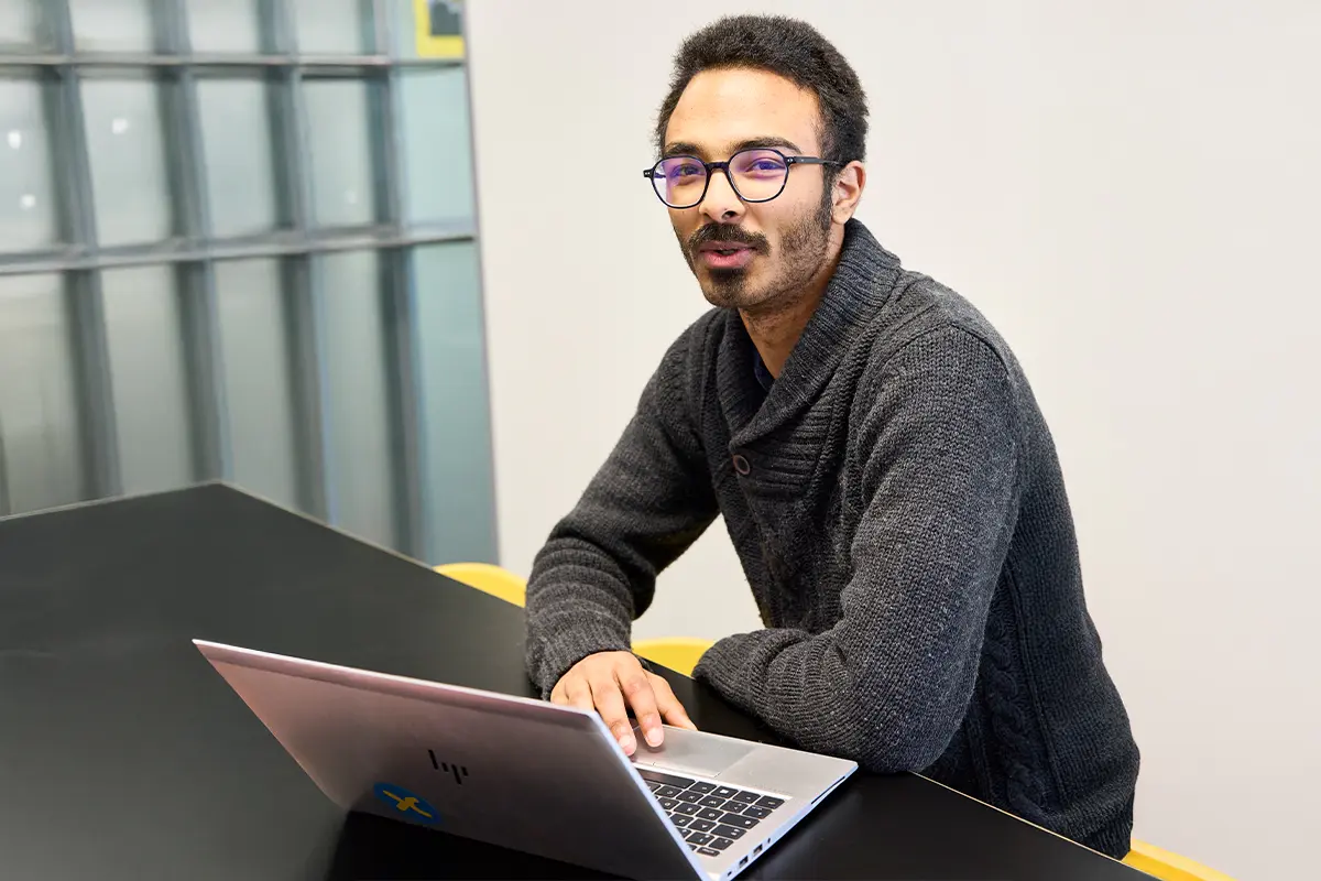 Thibaud pose derri&egrave;re son ordinateur