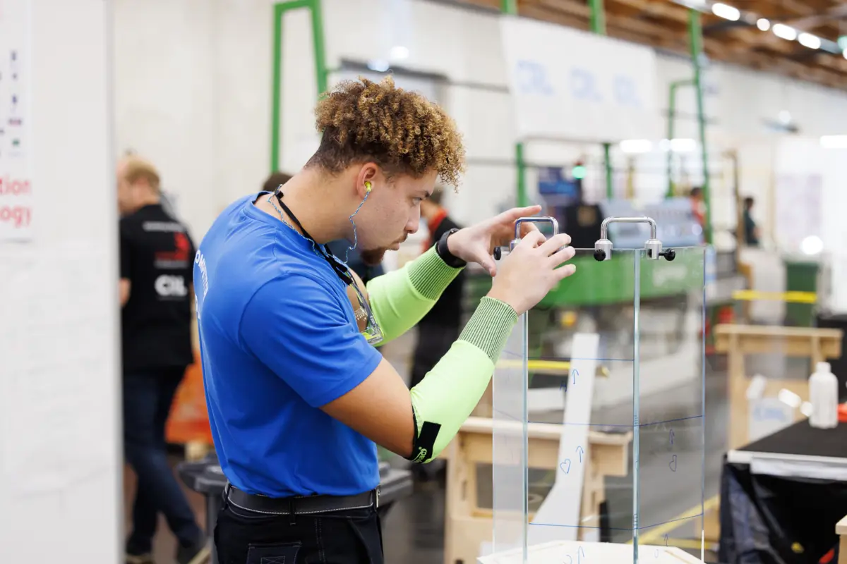 Jeune miroitier qui construit une table en verre