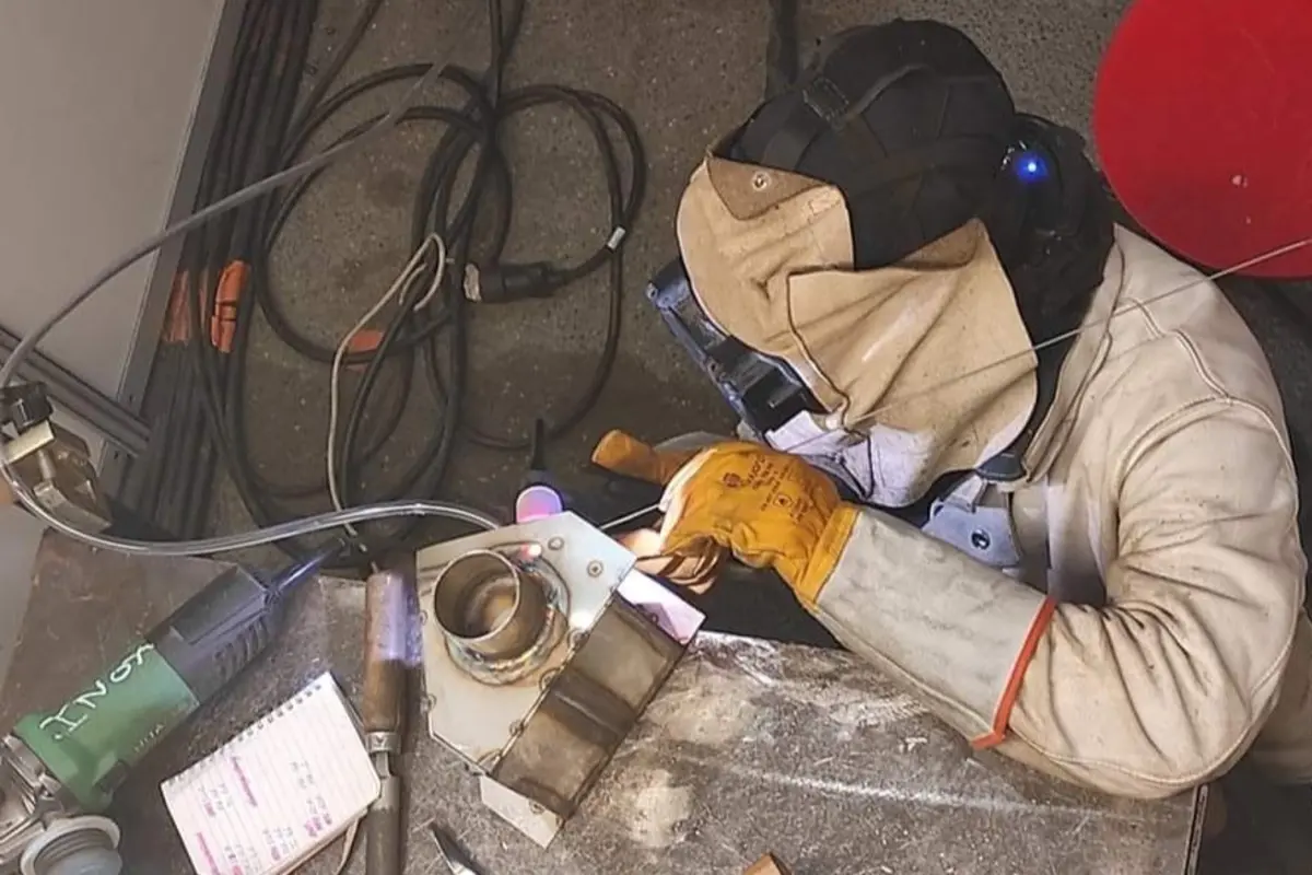 Jeune soudeuse r&eacute;alisant des travaux de soudure en atelier