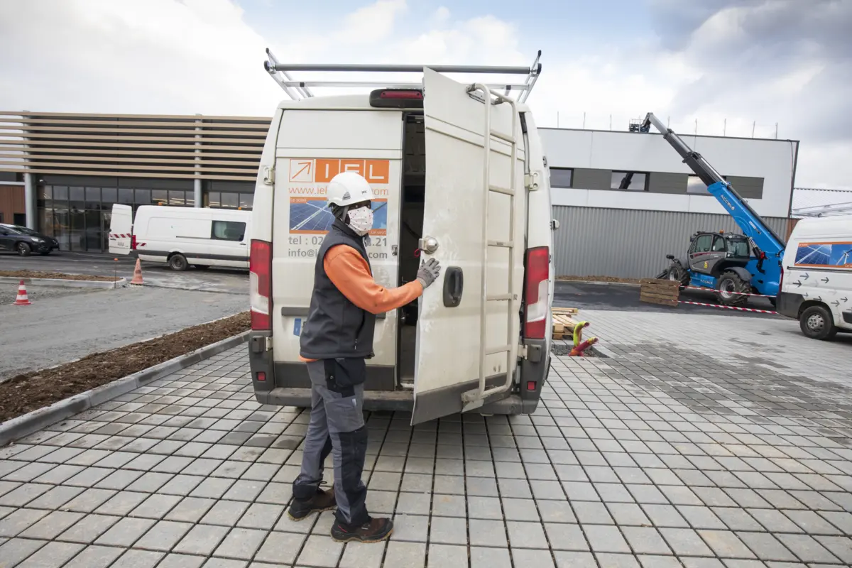 Un installateur ferme la porte d'une camionnette.