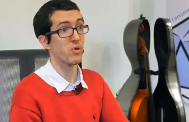 Photo de Charles-Marie Hulot avec son violoncelle dans le fond