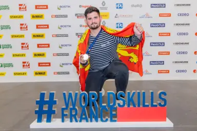 Un m&eacute;daill&eacute; Worldskills en horticulture pose avec sa m&eacute;daille en or.