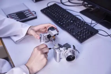 Gros plan sur les mains d'Hugo entrain de d&eacute;monter un appareils photo