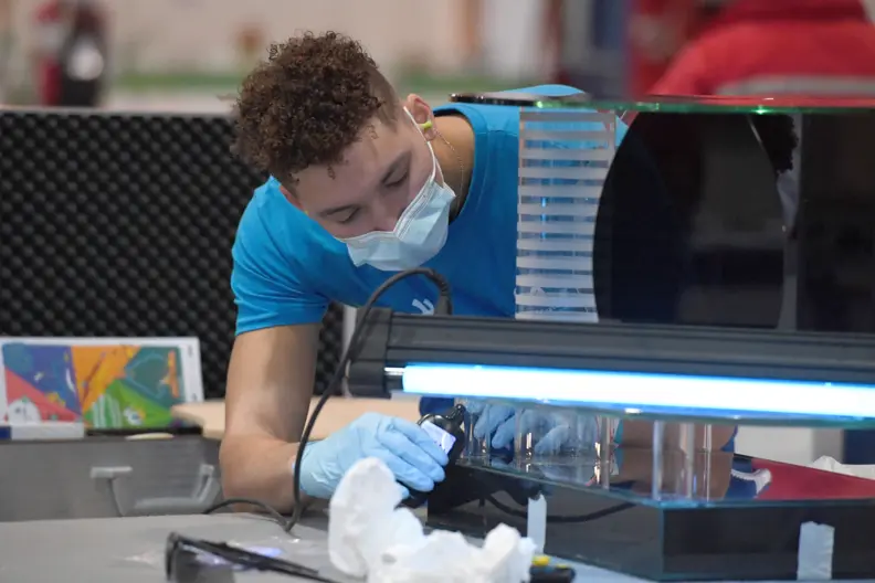 Jeune miroitier qui r&eacute;alise une table en verre