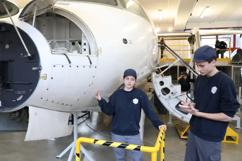 Deux &eacute;l&egrave;ves devant un morceau de carlingue d'avion