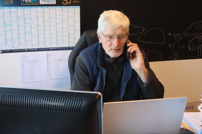 chef d'exploitation au t&eacute;l&eacute;phone devant ordinateur