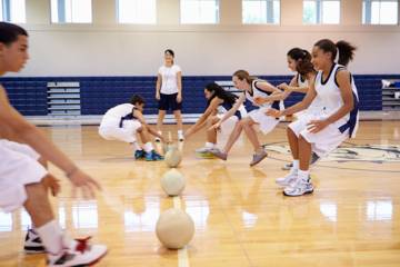 Des jeunes s'entraînant avec des ballons dans un gymnase